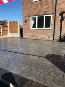 Pattern imprinted concrete driveway in Olde English Cobble with an acid stained edge