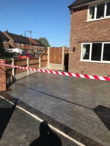 Pattern imprinted concrete driveway in Olde English Cobble with an acid stained edge